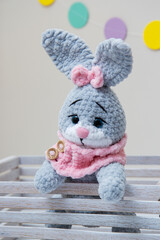 gray bunny soft toy with pink scarf