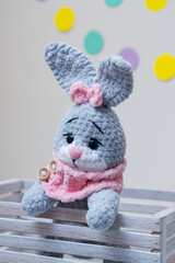 gray bunny soft toy with pink scarf