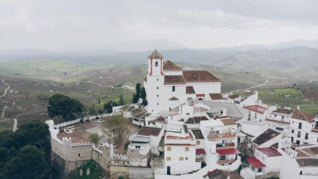 Drone of white town with the church at the top of the hill, Alozaina in Andalusia, Spain