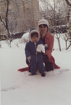 1979. Mom and son posing for a photo in a snowy garden.