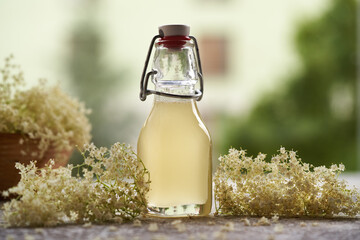 Elder flower syrup in a glass bottle outdoors