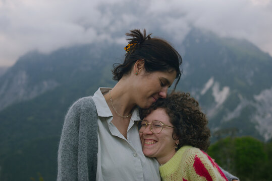 Two girlfriends hugging and smiling