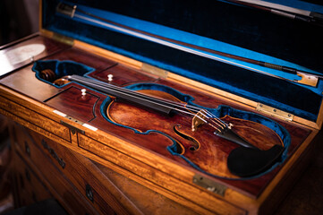 Detail of a historic high-end artisan violin in its case, a luxury collector's item from the 18th century. Made by a luthier with high quality wood © Adolf