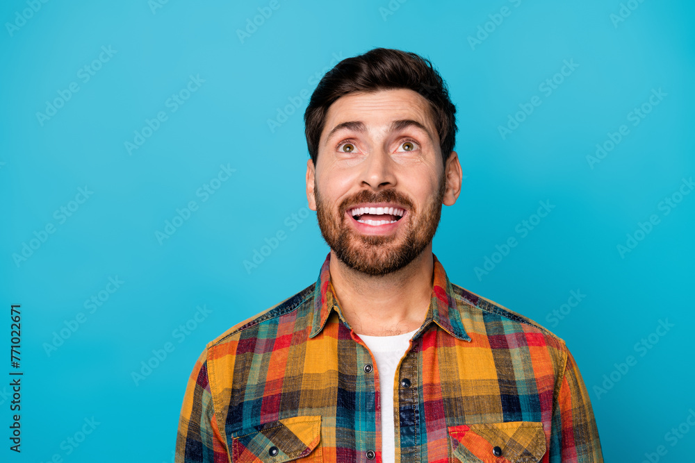 Poster portrait of inspired positive guy with stubble wear checkered shirt dreamy look up at offer empty sp