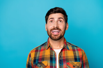Portrait of inspired positive guy with stubble wear checkered shirt dreamy look up at offer empty...