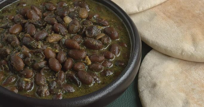 Black soybean curry. Pickled chlies, celery stalks and some pita breads on the side. Table spin. 