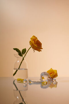 Dressing table with crystal and flower on reflective background.
