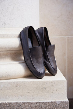 Stylish men's shoes stand on a column pilaster