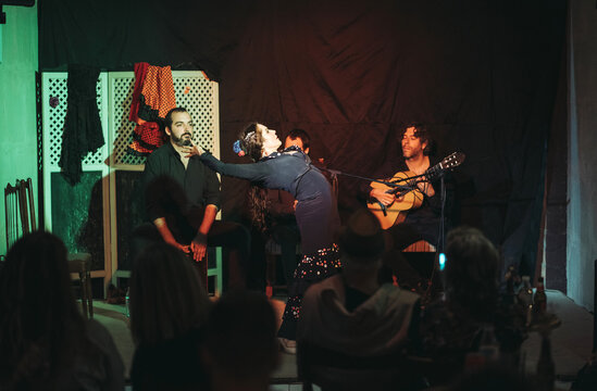 Group of Spanish musicians dancing and playing guitar on stage