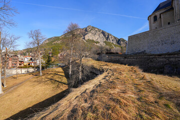 Moat of the walled city of Briançon built by Vauban in the French Alps - Citadel with colorful houses on top of a rocky spur in a mountainous valley in France - obrazy, fototapety, plakaty