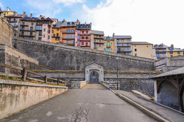 Gate of Embrun in the fortified wall of Briançon, a city built by Vauban in the French Alps - Citadel with colorful houses on top of a rocky spur in a mountainous valley in France - obrazy, fototapety, plakaty