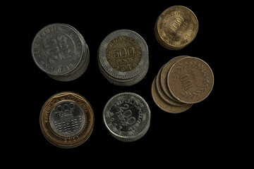 Colombian coins on both sides, isolated on black background: concept of economy, finance and trade in Colombia