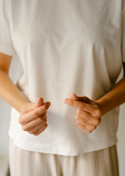 Closeup of a young woman making and showing mini heart hand sign