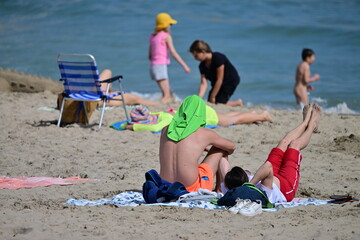 A young man doing sportive exercises at the beach of Benidorm-Spain on a hot and windy april day. 