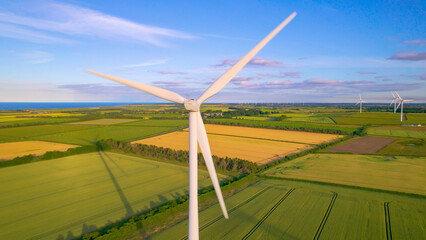 AERIAL, CLOSE UP Rotating wind turbine on a wind farm in the English countryside