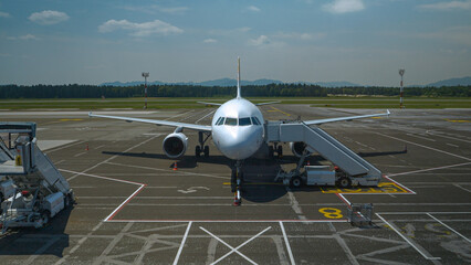 A grounded charter airplane at the airport terminal ready to board passengers - obrazy, fototapety, plakaty