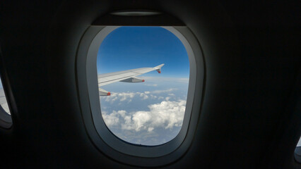POV: A view of the wing from a passenger plane flying high above fluffy clouds