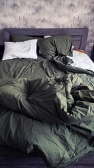 Rumpled bed. Green bed linen. Morning.