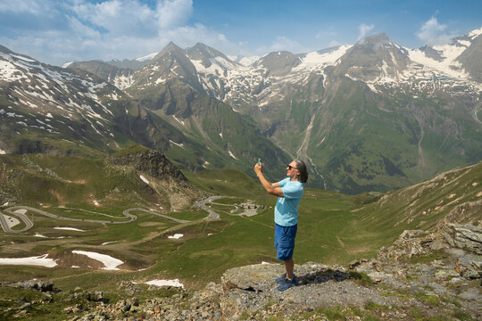 A senior man taking pictures of the mountains