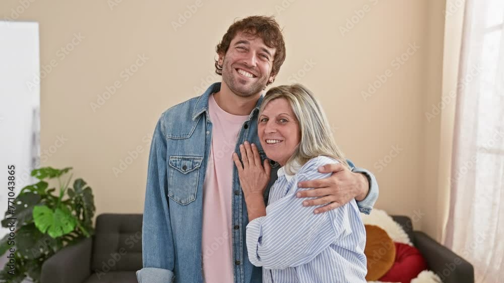 Wall mural confident mother and son share a warm, smiling hug indoors, enjoying their love-filled, casual lifes