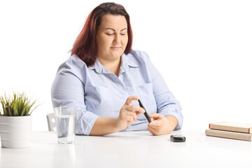 Corpulent young woman sitting and poking finger with an insulin
