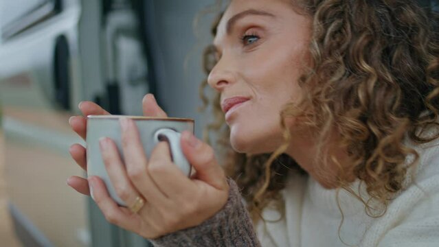 Closeup tourist holding cup with hot beverage sitting motorhome stairs portrait
