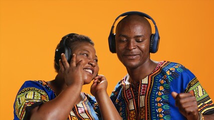 African american partners dancing on headset music in studio, having fun together with cool groovy...