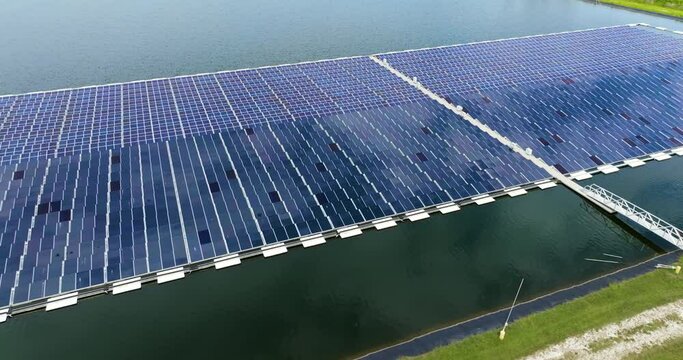 Floating photovoltaic power plant with many rows of solar panels for producing clean electrical energy. Concept of renewable electricity on water surface with no air pollution