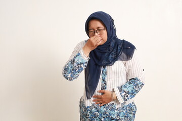 Asian elderly woman standing while covering her nose. Bad smell concept