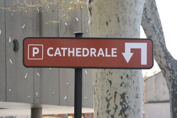 Panneau de signalisation montrant comment se rendre au parking de la cathédrale.