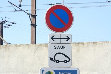 Panneaux de signalisation : interdiction de stationner, emplacement réservé à la recharge des véhicules électriques.