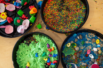 Sensory play bins, each filled with different colorful materials to stimulate the senses....