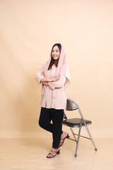full body semi-hijab Asian woman standing smiling chair with arms crossed. beautiful Muslim women for advertising, fashion, religion