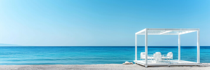 Crisp white cabana stands on pebble beach against the expansive blue sea, reflecting a minimalist and peaceful setting