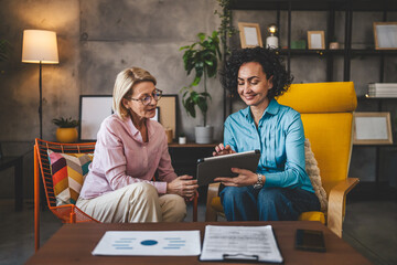 two women work on project at home use digital tablet have consultation