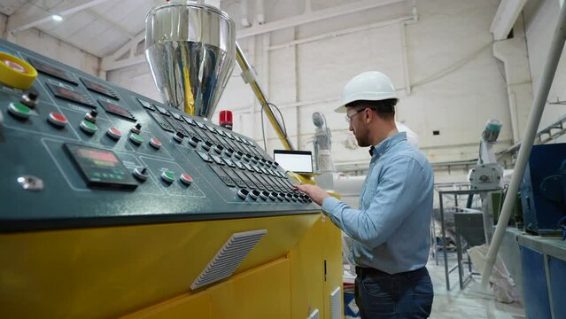 Engineer working at programmable CNC machine in factory industries