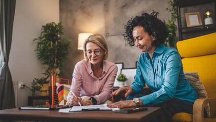 Two women work from home sign contract document or insurance policy