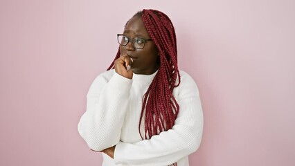 Pensive african woman with braids wearing glasses and a white sweater over a pink background - Powered by Adobe