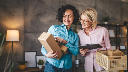 two women entrepreneur at home pack boxes product order for delivery