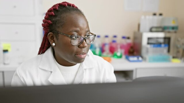 African american female scientist with braids working in a laboratory setting, focused and professional.