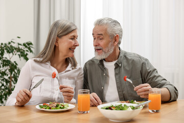 Happy senior couple having dinner at home