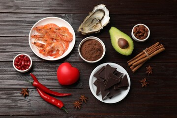 Natural aphrodisiac. Different food products and red decorative heart on dark wooden table, flat lay