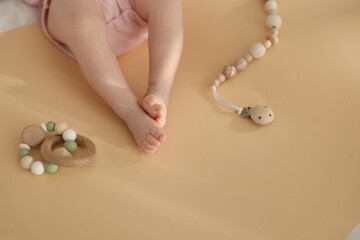 Cute baby and rattle toys on beige background, closeup. Space for text