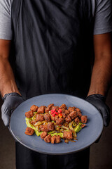 hombre sosteniendo un plato de chicharron de atun, comida tipica mexicana 