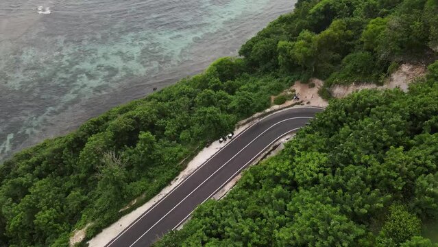 Aerial view, cliffside asphalt road and sea located on Tanah Barak beach, Bali island, Indonesia.