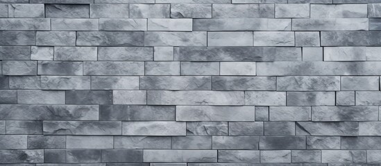 Obraz premium A detailed closeup of a rectangular grey brick wall showcasing the intricate brickwork pattern. The composite material is commonly used as a building material for walls and flooring