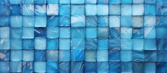 An artistic display of Azure, Aqua, and Electric blue tiles arranged in a geometric pattern on a glass wall. The liquidlike texture creates a mesmerizing effect