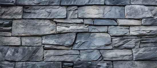 A detailed closeup of a grey stone wall composed of rectangular bricks, showcasing the intricate pattern of the composite building material