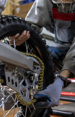 The master is busy repairing a mountain bike in the garage. wheel, chain, tire, engine and other...