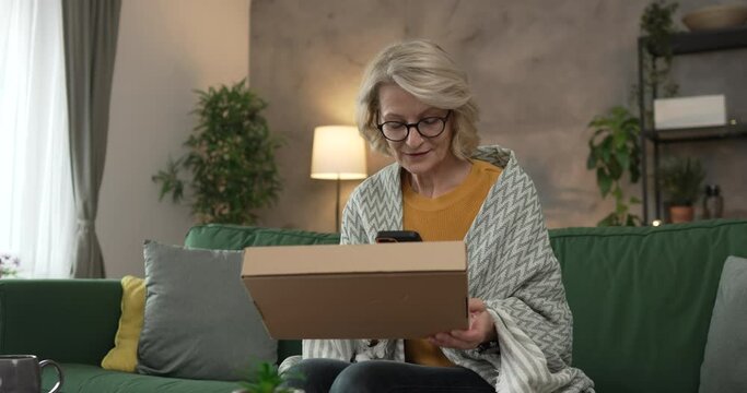 one woman checking box of received package or product at home